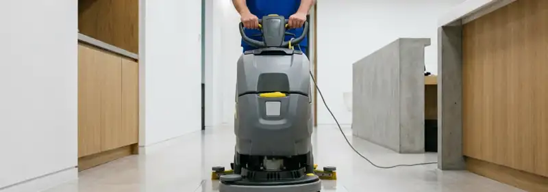 Janitorial staff using a floor scrubber machine to clean a commercial hallway, Tucson, AZ.